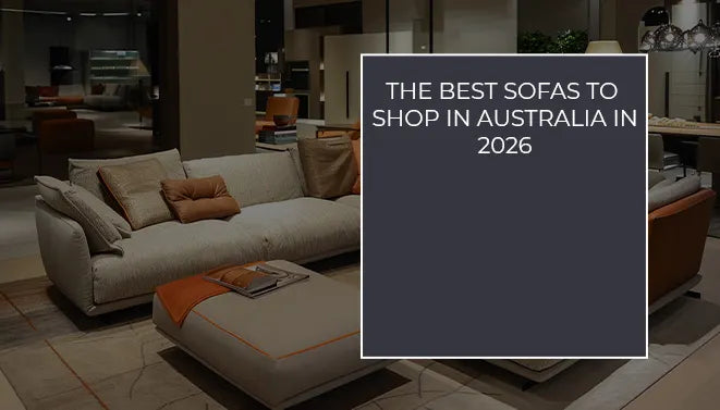 luxury light-grey sectional sofa with orange accent pillows and a matching ottoman in a high-end Australian furniture gallery