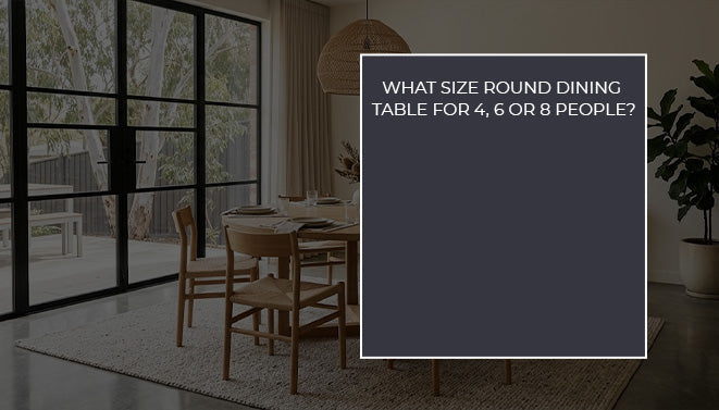 Round wooden dining table with matching chairs in a modern dining room with large windows and natural lighting.