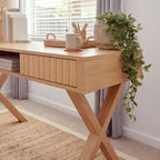 Arden 140cm Home Office Desk Natural, close-up of a fluted drawer front and a crossed leg