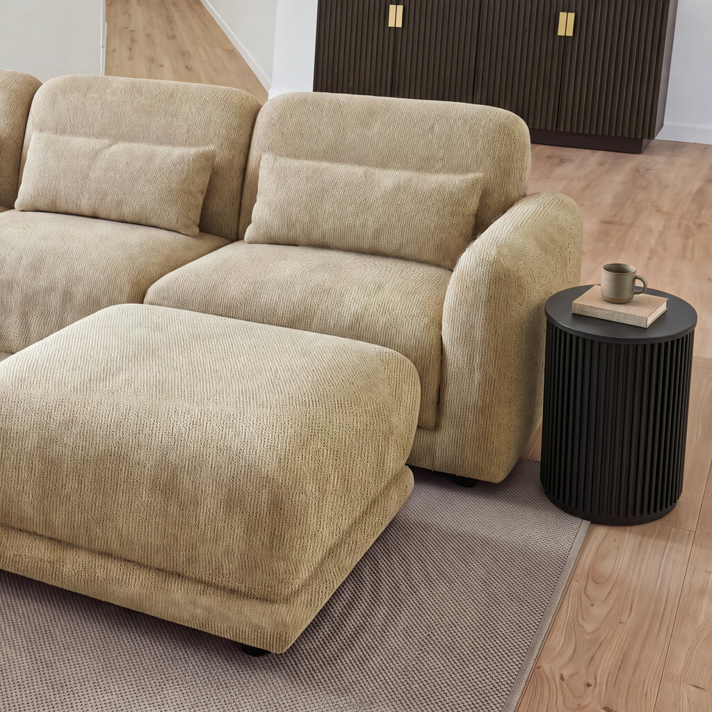 Ayla Fluted 40cm Round Side Table Black beside a modular sofa and ottoman, with a sideboard behind