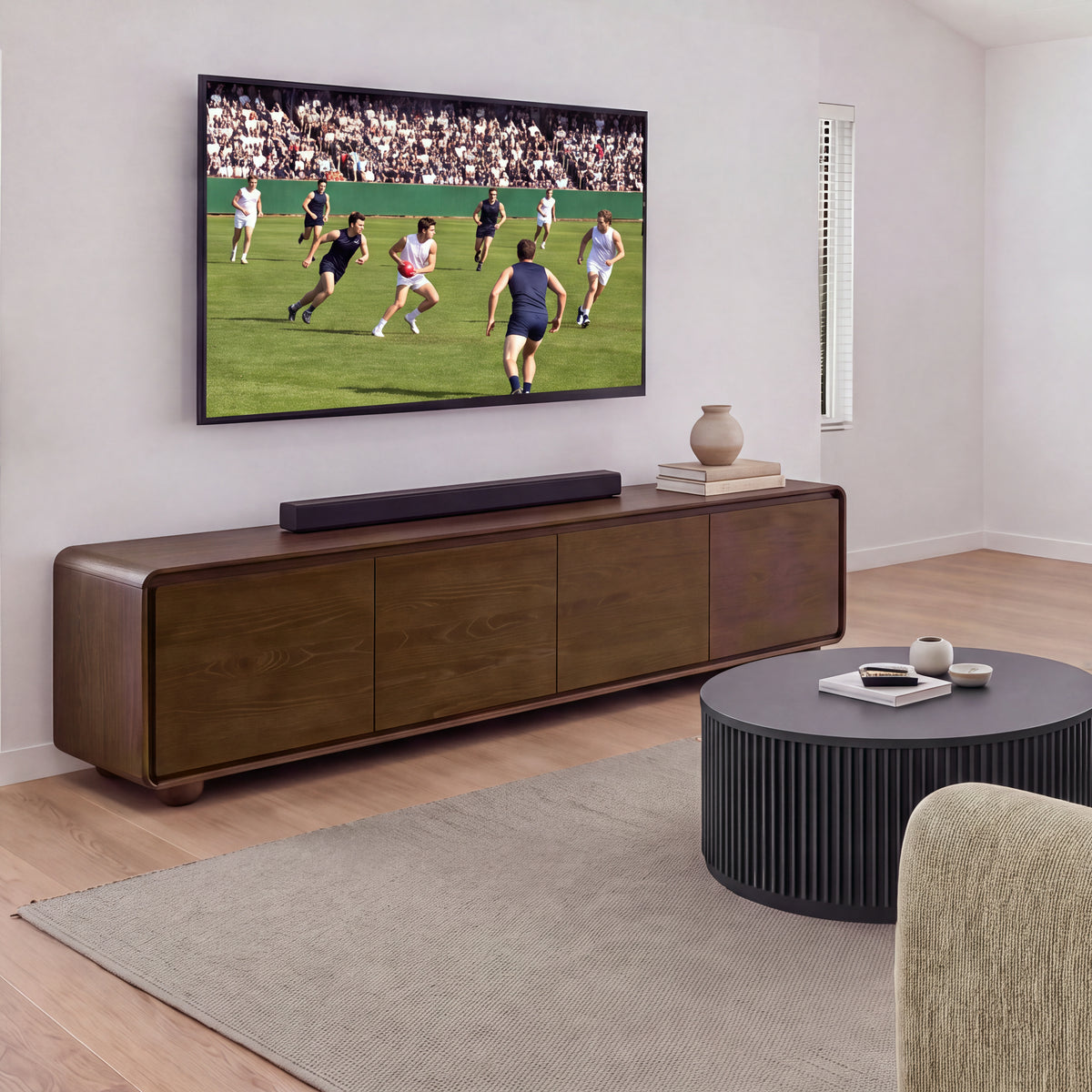 Ayla Fluted 90cm Round Coffee Table Black in a living room facing a TV unit and wall-mounted TV, wide view
