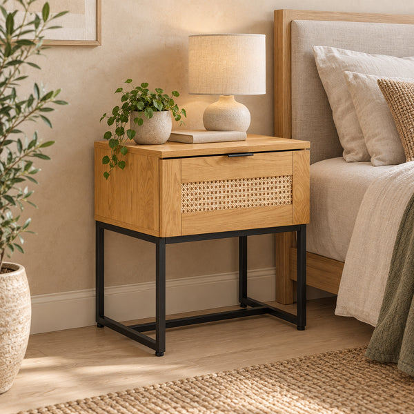 Debora 1 Drawer Bedside Table Oak, beside a bed with a table lamp on top