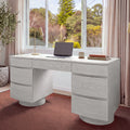 Dorit 172cm 7 Drawer Home Office Desk White in a home office in front of a garden window, with a laptop and a desk lamp on top