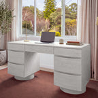 Dorit 172cm 7 Drawer Home Office Desk White in a home office in front of a garden window, with a laptop and a desk lamp on top