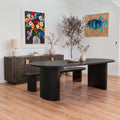 Eve 240cm Oval Dining Table Black in a dining room with a matching bench behind it and a reeded sideboard against the wall