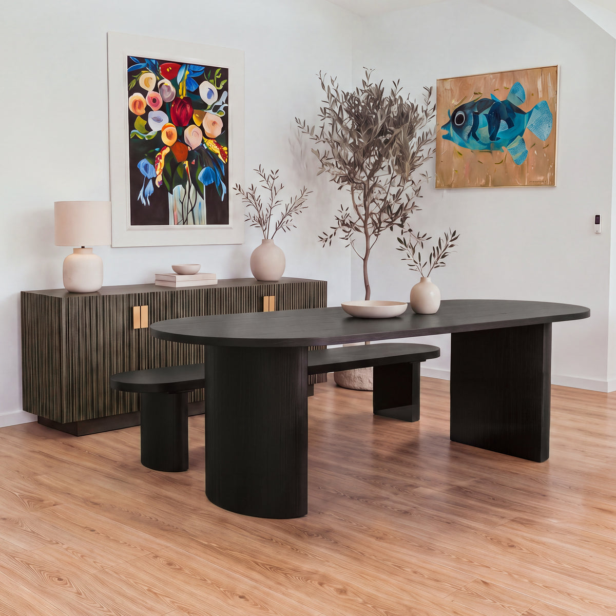 Eve 240cm Oval Dining Table Black in a dining room with a matching bench behind it and a reeded sideboard against the wall