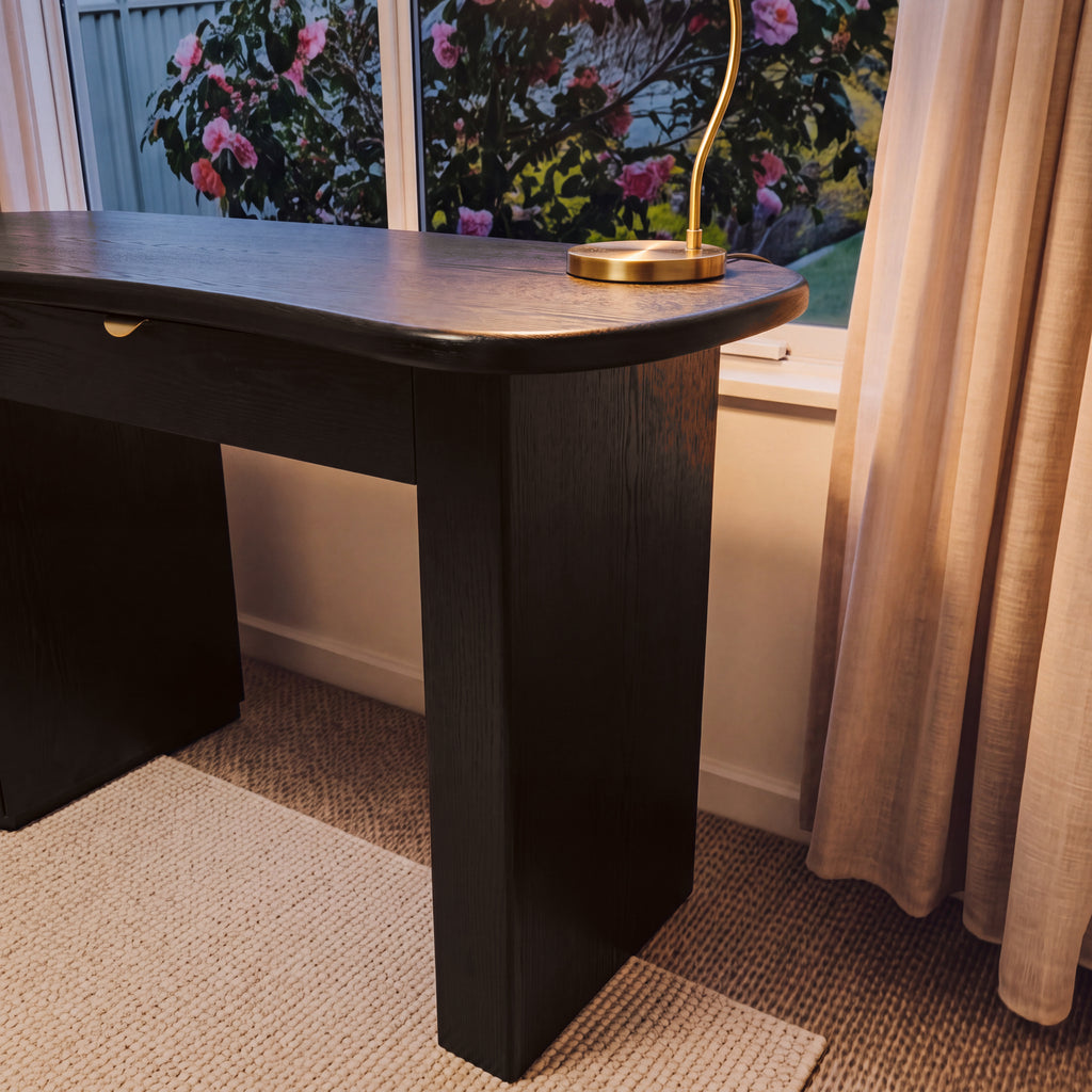 Golborne 150cm Home Office Desk Black, close-up of the end panel and curved top with a brass lamp