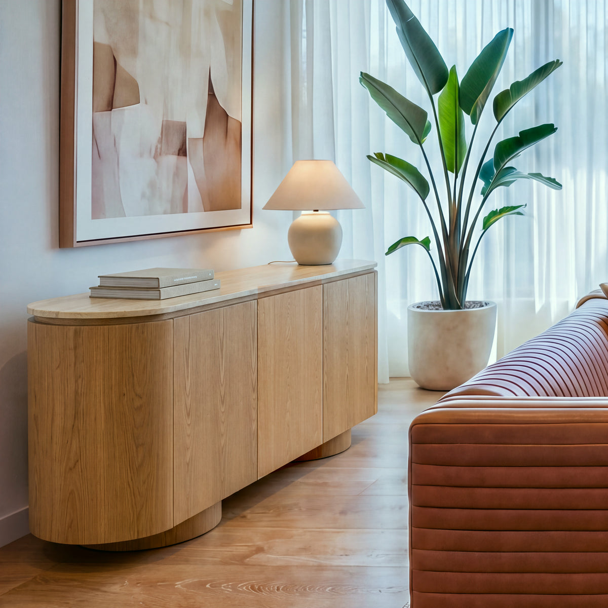 Hera 180cm Sideboard Buffet Table Natural, three-quarter view beside a leather sofa and an indoor plant