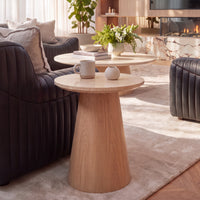 Hera 55cm Round Side Table Natural, beside a sofa in a living room, with a matching coffee table