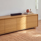 Hudson Jenny 220cm ETU Entertainment TV Unit Natural, close view of the doors, rounded corner and bun foot, with a soundbar, vase and books on top