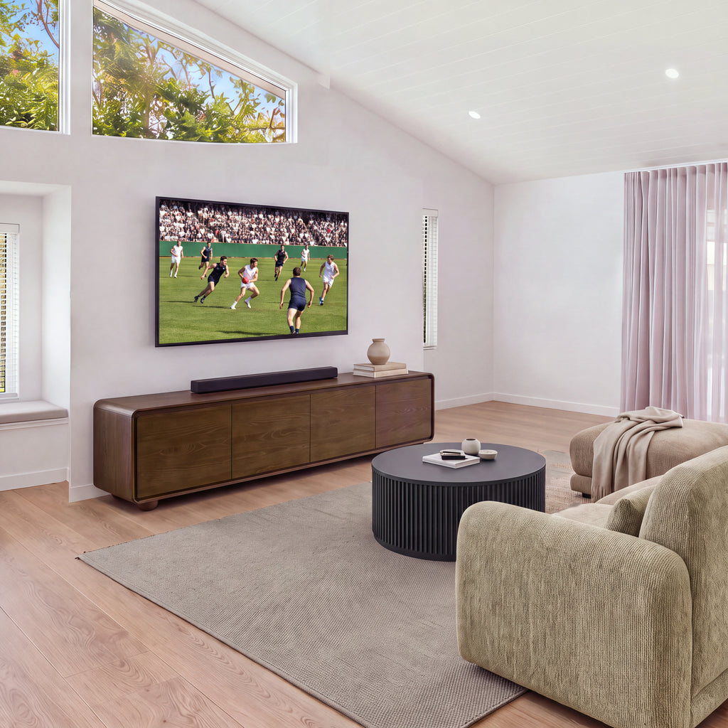 Hudson Jenny 220cm ETU Entertainment TV Unit Walnut in a living room with a high window, a sofa and a fluted round coffee table, wide view