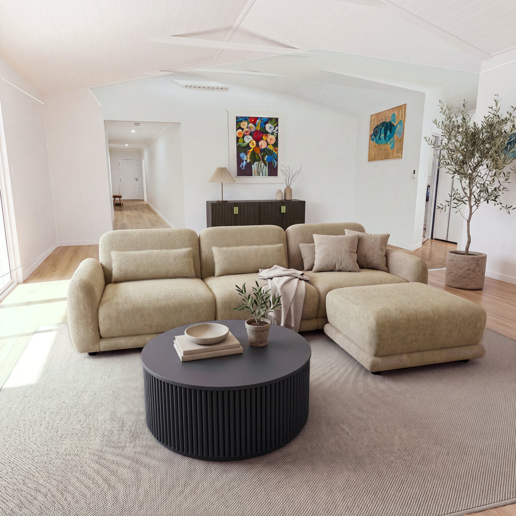 Paulie 270cm 3 Seater Modular Sofa with Ottoman Latte in an open-plan living room with a round black fluted coffee table and a sideboard behind