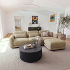 Paulie 270cm 3 Seater Modular Sofa with Ottoman Latte in an open-plan living room with a round black fluted coffee table and a sideboard behind