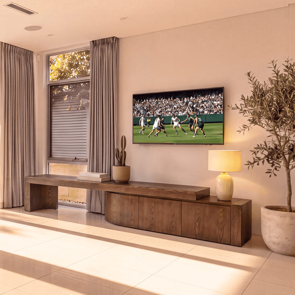 Ruvos 213-280cm Extendable ETU Entertainment TV Unit Walnut, beneath a wall-mounted TV in a living room