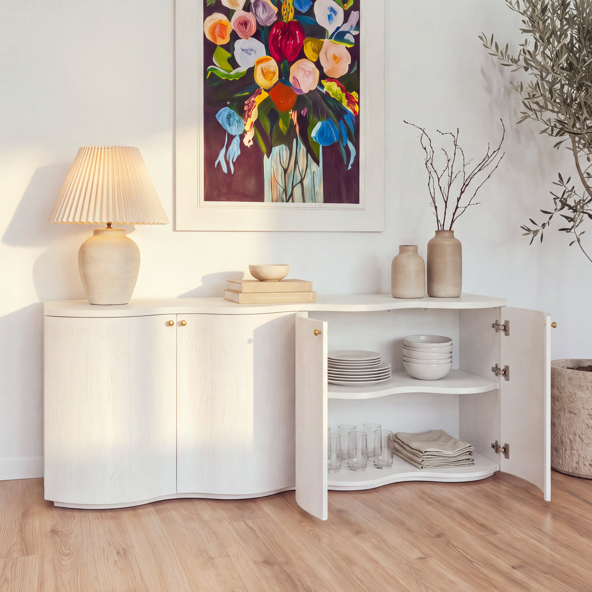 Wave white buffet with its right-hand doors open showing dinnerware, in late-afternoon lamplight