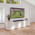 Wave white entertainment unit under a wall-mounted TV in a bright living room, front three-quarter view